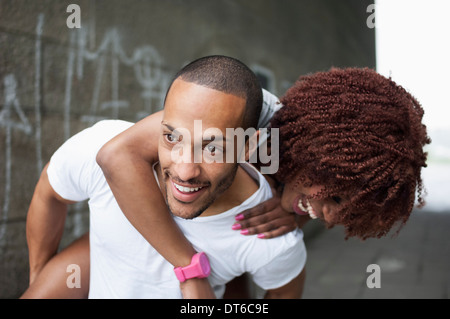 Young man giving woman piggyback Banque D'Images