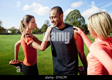 L'homme et de la femme s'étend les jambes dans park Banque D'Images