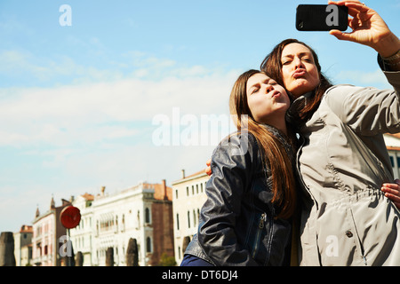 Mère et fille en tenant sur smartphone selfies, Venise, Italie Banque D'Images