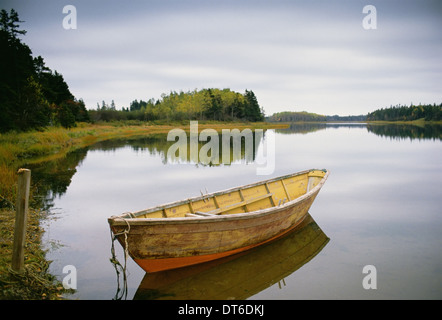 Un petit bateau à rames ou dory en bois amarré sur une eau calme, dans Savage Harbour sur l'Île du Prince-Édouard au Canada. Banque D'Images