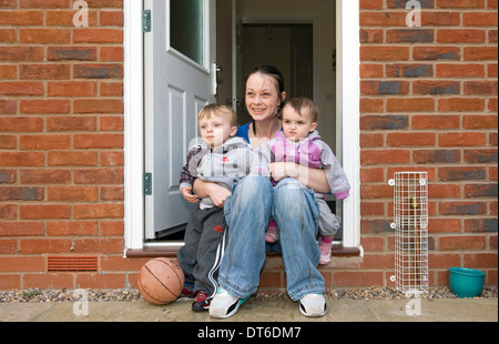 Une jeune mère de jouer avec ses deux enfants dans leur maison. Banque D'Images