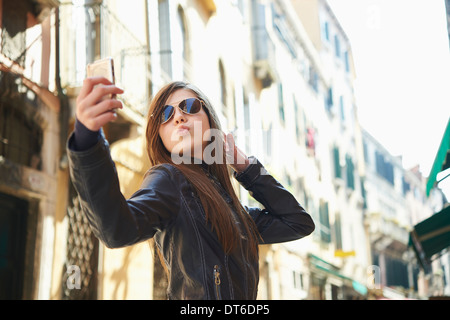 Girl taking sur smartphone selfies, Venise, Italie