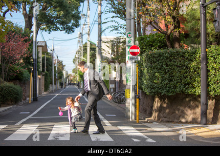 Père et fille crossing zebra crossing Banque D'Images