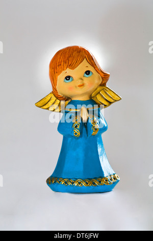 Un joli petit ange avec de grands yeux et des ailes d'or sur un nuage Banque D'Images