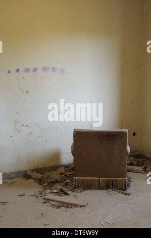 Fauteuil face au mur. Salle vide dans la maison abandonnée de l'intérieur. Banque D'Images