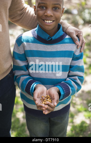 Un nouveau parc de la ville de New York au printemps. Soleil et fleur de cerisier. Une mère et son fils, un garçon tenant une poignée de noix. Banque D'Images