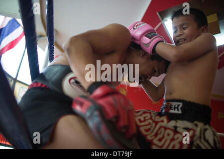 Chiang Mai, Thaïlande. 24 Jan, 2014. L'accent s'entraîne avec son père à la Muay Thai gym dans le centre de Chiang Mai. Focus' père était un chasseur professionnel à Bangkok avant de prendre sa retraite. PETCHFOGUS SITTHAHARNAEK, 9, alias Focus est le top fighter pour son âge et poids à Chiang Mai. Il a commencé la lutte contre les anciens adversaires plus lourds, de continuer à améliorer ses compétences. Combattants sont généralement versées 1 000 bahts (30) pour se battre. © Taylor Weidman/ZUMA/ZUMAPRESS.com/Alamy fil Live News Banque D'Images