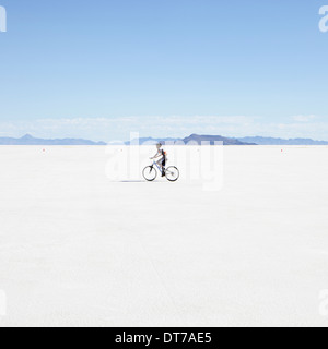 Boy riding bike sur les plaines salines au cours de la semaine de vitesse de Bonneville Salt Flats en Utah USA Banque D'Images