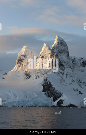 Lever du soleil sur les sommets des montagnes à l'entrée nord de la Canal Lemaire le long de la péninsule Antarctique Banque D'Images