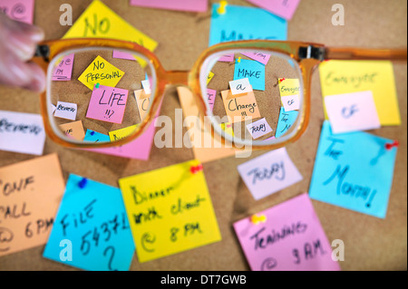 Carrière et vie personnelle. De longues heures de travail. Les messages sur post-it sur un liège message board. Banque D'Images