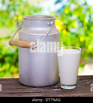Lait en verre et aluminium sur la vieille table en bois de plein air. Banque D'Images