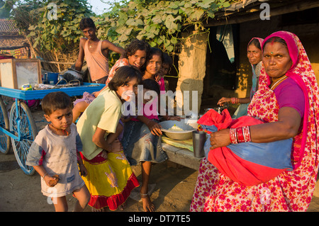 Femme dans un sari rouge, et un groupe d'enfants à un foodstall dans le village de Sonepur, au moment de l'Sonepur Mela, Bihar, Inde Banque D'Images