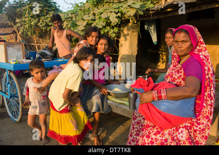 Femme dans un sari rouge, et un groupe d'enfants à un foodstall dans le village de Sonepur, au moment de l'Sonepur Mela, Bihar, Inde Banque D'Images