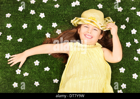 Cute little girl pose dans un champ plein de fleurs Banque D'Images