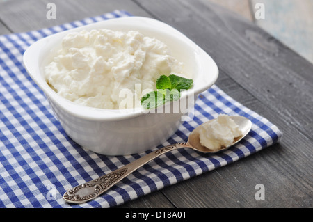 Dans un bol de fromage ricotta à la menthe sur fond de bois Banque D'Images