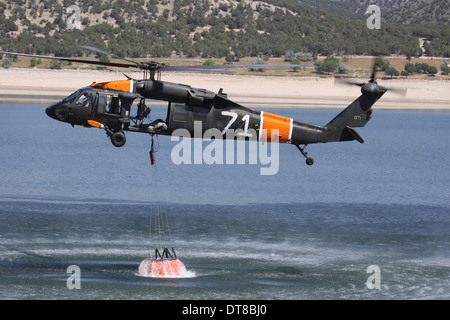 L'ARMÉE AMÉRICAINE UN UH-60 Black Hawk recueille l'eau d'un réservoir. Banque D'Images