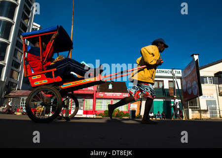 L'extraction d'un pousse pousse dans les rues d'Antsirabe, Madagascar. Banque D'Images