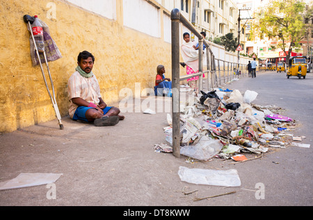 Pauvre homme handicapé mendiant dans une rue en face de la foutaise. L'Andhra Pradesh, Inde Banque D'Images