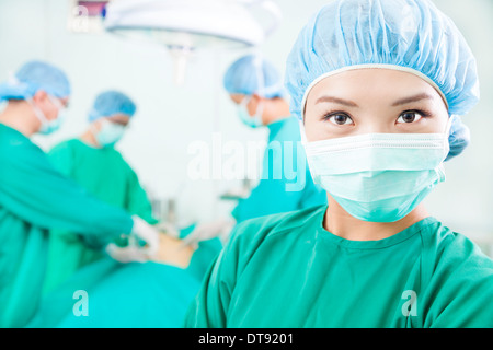 Femme de chirurgie et chirurgiens dans un bloc opératoire à l'hôpital Banque D'Images