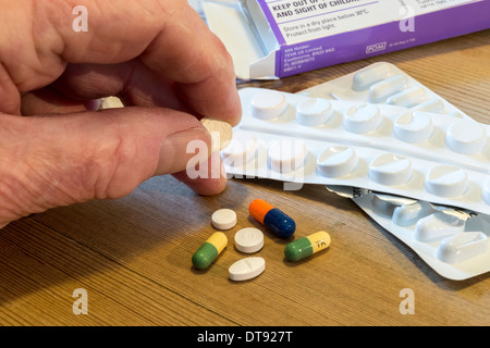 La main de l'homme âgée avec sélection de comprimés pour médication quotidienne. Banque D'Images