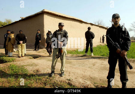 Peshawar, Pakistan. 12 Février, 2014. Les responsables de la sécurité alerte stand pour éviter des incidents fâcheux sur le site après que des terroristes ont attaqué un policier à la maison Mashokhel Badaber à Peshawar le mercredi, 12 février, 2014. Au moins neuf personnes ont été tuées, des terroristes ont attaqué un policier's house situé à Badaber dans Mashokhel la périphérie mercredi. La police a déclaré que plus d'une douzaine de militants inconnus armés d'armes lourdes a attaqué une maison située à Mashokhel. Selon certaines sources, seuls les hommes ont été pris pour cible dans l'incident, tandis que, les femmes et les enfants sont restés en sécurité. © Fahad Pervez/PPI J Banque D'Images