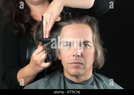 L'homme de longs cheveux coupés pour le cancer Fundraiser Banque D'Images