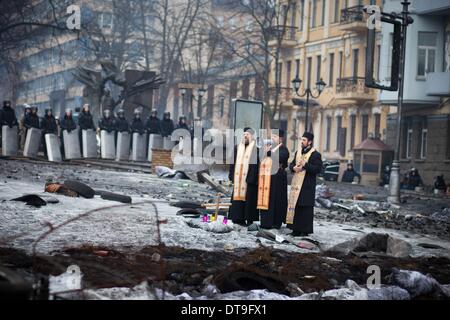 Kiev, Ukraine. 12 Février, 2014. Les prêtres prier entre manifestants et policiers sur les lieux de manifestations anti-gouvernementales près de Dynamo Stadium le 12 février 2014 à Kiev, Ukraine. De violentes manifestations en Ukraine se sont répandues au-delà de la capitale que le Président Viktor Ianoukovitch a tenu une réunion de crise avec les trois principaux dirigeants de l'opposition. Photo par Emeric Fohlen/NurPhoto Crédit : Emeric Fohlen/NurPhoto ZUMAPRESS.com/Alamy/Live News Banque D'Images