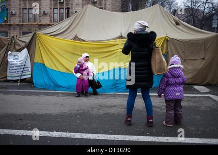 Kiev, Ukraine. 12 Février, 2014. Femme prend des photos d'elle et son enfant près d'un manifestant anti tente dans la place de l'indépendance le 12 février 2014. La Russie va lancer le prochain versement de la somme de 15 milliards de dollars de prêt à l'Ukraine à la fin du mois, un journal proche du Président Viktor Ianoukovitch a déclaré le 10 février, à la suite de pourparlers entre le chef de l'Ukraine et son homologue russe. Photo par Emeric Fohlen/NurPhoto Crédit : Emeric Fohlen/NurPhoto ZUMAPRESS.com/Alamy/Live News Banque D'Images