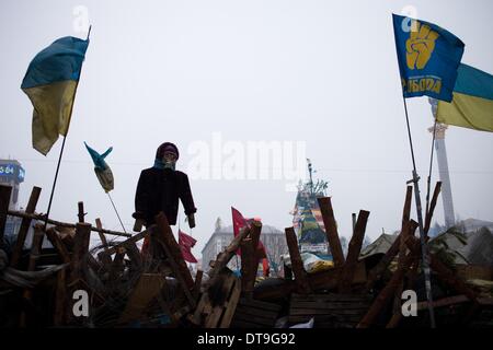 Kiev, Ukraine. 12 Février, 2014. Drapeaux et masque à gaz sur une barricade montée à la place de l'indépendance le 12 février 2014. La Russie va lancer le prochain versement de la somme de 15 milliards de dollars de prêt à l'Ukraine à la fin du mois, un journal proche du Président Viktor Ianoukovitch a déclaré le 10 février, à la suite de pourparlers entre le chef de l'Ukraine et son homologue russe. Photo par Emeric Fohlen/NurPhoto Crédit : Emeric Fohlen/NurPhoto ZUMAPRESS.com/Alamy/Live News Banque D'Images