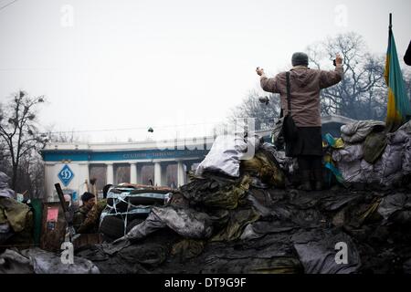 Kiev, Ukraine. 12 Février, 2014. Une femme se tient sur les manifestants des barricades d'élever ses mains dans le ciel le 12 février 2014. La Russie va lancer le prochain versement de la somme de 15 milliards de dollars de prêt à l'Ukraine à la fin du mois, un journal proche du Président Viktor Ianoukovitch a déclaré le 10 février, à la suite de pourparlers entre le chef de l'Ukraine et son homologue russe. Photo par Emeric Fohlen/NurPhoto Crédit : Emeric Fohlen/NurPhoto ZUMAPRESS.com/Alamy/Live News Banque D'Images