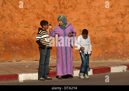 Mère en costume traditionnel avec foulard et djellaba, avec ses deux fils dans les vêtements occidentaux, Médine ou centre historique Banque D'Images