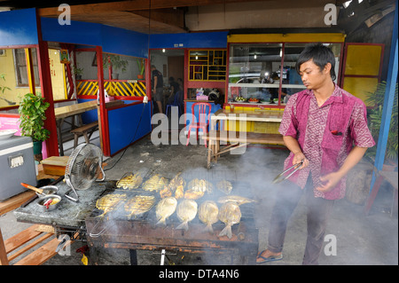 Man grilling javanaise poisson dans un restaurant, Biak, ville de l'île de Biak, Papouasie occidentale, en Indonésie Banque D'Images