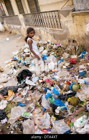 Les Indiens pauvres basse caste Girl standing in détritus abandonnés dans une rue de la ville. L'Andhra Pradesh, Inde Banque D'Images