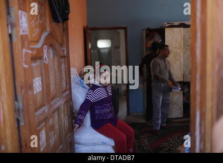 Gaza, bande de Gaza. Feb 13, 2014. Un 12-year-old fille palestinienne Rula Ali (L), qui souffre d'une laryngite chronique, est vu à sa maison dans le camp de réfugiés de Nuseirat, centre de la bande de Gaza, le 13 février 2014. Plusieurs patients palestiniens comme Rula qui sont en quête d'un traitement en Israël se sont vu refuser l'accès par les autorités israéliennes par Erez avec Gaza pour la tenue de documents en utilisant le terme "État de Palestine". © Wissam Nassar/Xinhua/Alamy Live News Banque D'Images