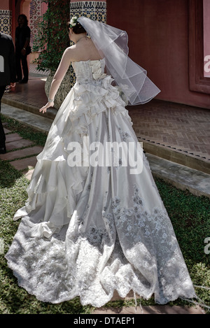 Robe de mariée. Vue arrière d'une robe de mariage et d'un voile de tête de mariée traditionnelle en satin blanc. Banque D'Images