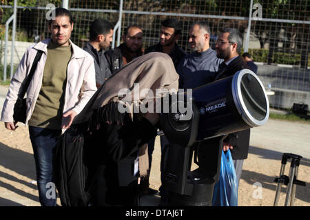 La ville de Gaza, bande de Gaza, territoire palestinien. Feb 13, 2014. Un étudiant palestinien regarde à travers un télescope vers le soleil au cours d'une formation pratique pour identifier l'astronome de taches de couleur et son impact, dans la ville de Gaza le 13 février 2014 Credit : Ashraf Amra/APA Images/ZUMAPRESS.com/Alamy Live News Banque D'Images