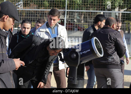 La ville de Gaza, bande de Gaza, territoire palestinien. Feb 13, 2014. Un étudiant palestinien regarde à travers un télescope vers le soleil au cours d'une formation pratique pour identifier l'astronome de taches de couleur et son impact, dans la ville de Gaza le 13 février 2014 Credit : Ashraf Amra/APA Images/ZUMAPRESS.com/Alamy Live News Banque D'Images