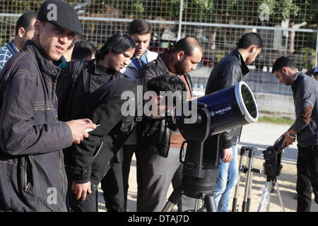 La ville de Gaza, bande de Gaza, territoire palestinien. Feb 13, 2014. Un étudiant palestinien regarde à travers un télescope vers le soleil au cours d'une formation pratique pour identifier l'astronome de taches de couleur et son impact, dans la ville de Gaza le 13 février 2014 Credit : Ashraf Amra/APA Images/ZUMAPRESS.com/Alamy Live News Banque D'Images