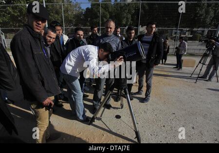 La ville de Gaza, bande de Gaza, territoire palestinien. Feb 13, 2014. Un étudiant palestinien regarde à travers un télescope vers le soleil au cours d'une formation pratique pour identifier l'astronome de taches de couleur et son impact, dans la ville de Gaza le 13 février 2014 Credit : Ashraf Amra/APA Images/ZUMAPRESS.com/Alamy Live News Banque D'Images