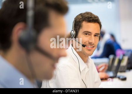 Portrait of Businessman in office sur votre téléphone avec casque, à huis clos Banque D'Images