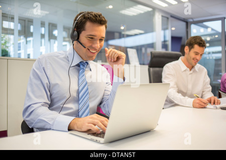 Businessman in office sur votre téléphone avec la conférence téléphonique, casque Banque D'Images