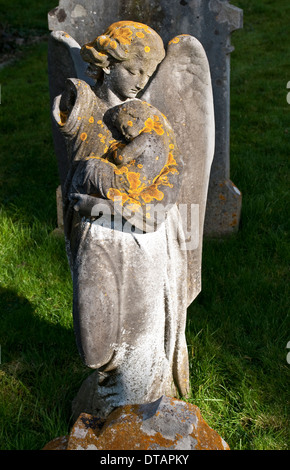 Ange funèbre avec un bébé statue dans le cimetière de l'église paroissiale, Leatherhead, Surrey, England, UK Banque D'Images