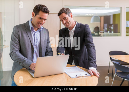 Deux hommes d'affaires occasionnels travaillant ensemble dans un bureau moderne avec coffre Banque D'Images