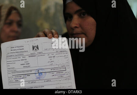 La ville de Gaza. Feb 13, 2014. Un patient palestinien affiche son document écrit "État de Palestine" délivrée par le ministère de la santé à la gestion du Hamas à Gaza, le 13 février 2014. Des dizaines de patients palestiniens qui cherchent à obtenir un traitement en Israël se sont vu refuser l'accès par les autorités israéliennes par Erez avec Gaza pour la tenue de documents en utilisant le terme "État de Palestine". Credit : Wissam Nassar/Xinhua/Alamy Live News Banque D'Images