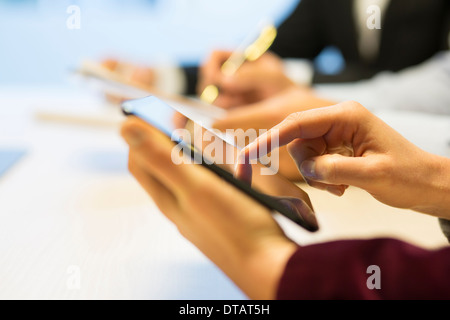 Close-up of Businesswoman mains écrit sur tablette numérique au cours d'une réunion Banque D'Images