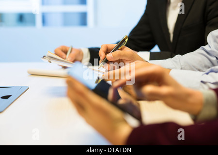 Close-up of Businessman mains écrit sur papier au cours d'une réunion Banque D'Images