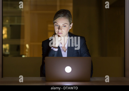 Businesswoman travailler tard dans son bureau sur l'ordinateur portable Banque D'Images