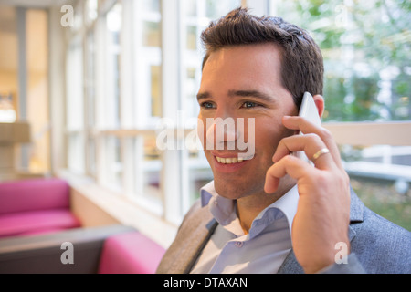 Happy smiling young woman on phone in office Banque D'Images