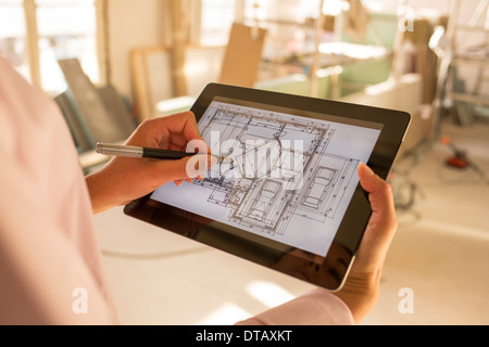 Femme architecte dessiner avec un stylet sur tablette électronique en construction site Banque D'Images