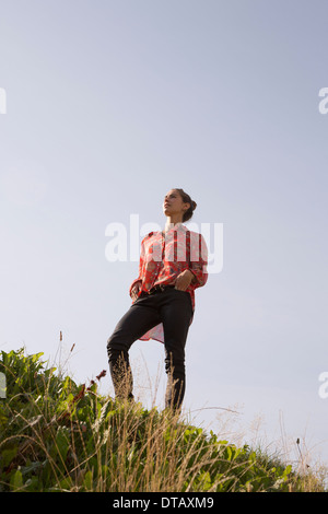 Young woman standing in park, low angle view Banque D'Images